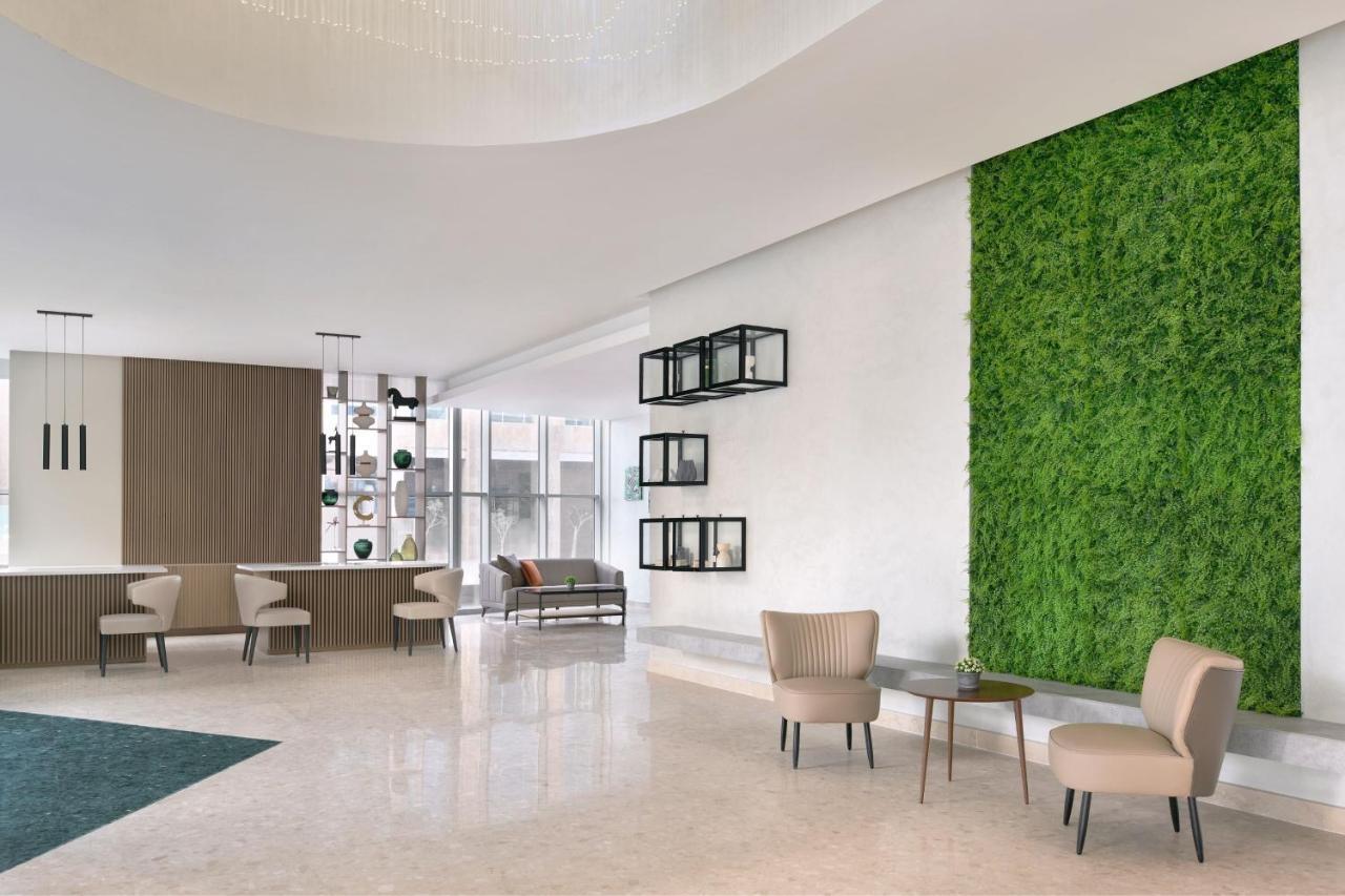 Element By Westin West Bay Doha Hotel Bagian luar foto A green wall in a hotel lobby